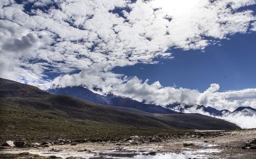 Scenic view of mountains against cloudy sky