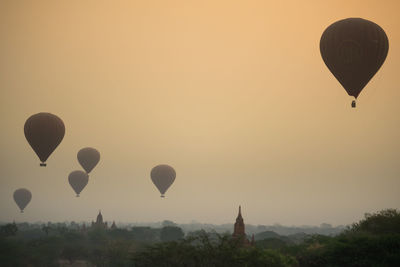 Hot air balloons flying in sky at sunset