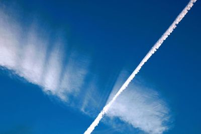 Low angle view of airplane flying against clear blue sky