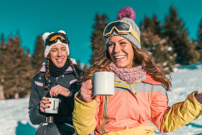 Portrait of happy friends in snow during winter