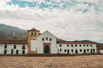 Exterior of houses by buildings against sky