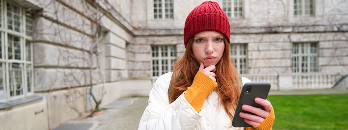 Young woman using mobile phone in city