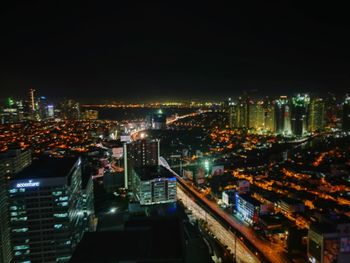 High angle view of illuminated cityscape against sky at night