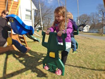 Children enjoying on swing at park