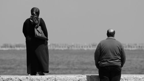 Rear view of man and woman by sea