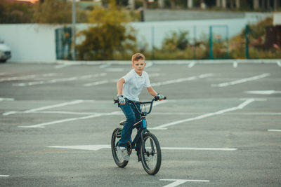 Boy riding bicycle on road in city