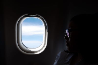 Close-up of woman by airplane window