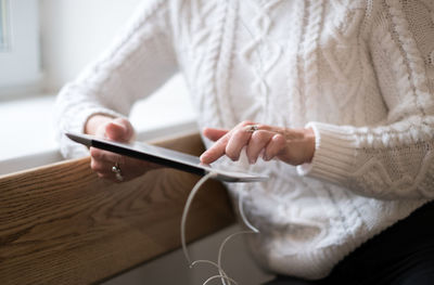 Midsection of woman using mobile phone at home