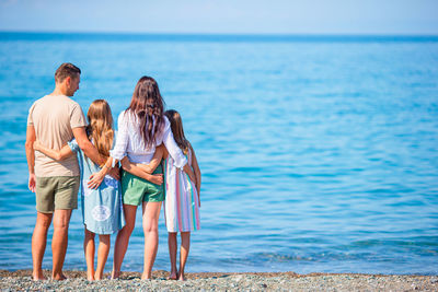 Rear view of women standing on beach