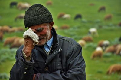 Sad herder standing on field