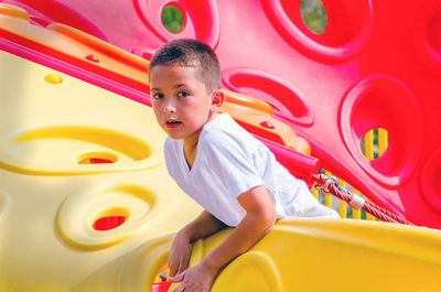 Little boy posing from on top of a play structure