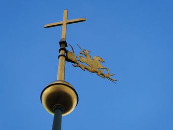 Low angle view of cross against clear blue sky