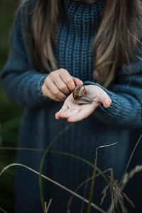 Midsection of woman holding snail