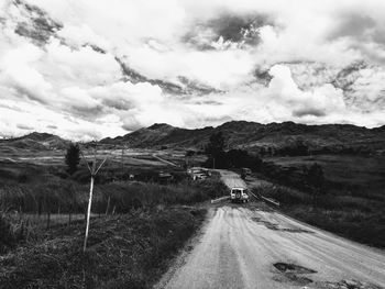 Road leading towards mountains against sky