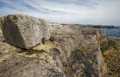 Rock formation on beach against sky