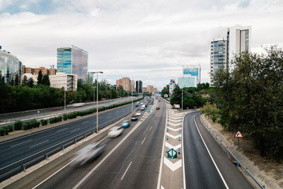 Cars on road in city against sky