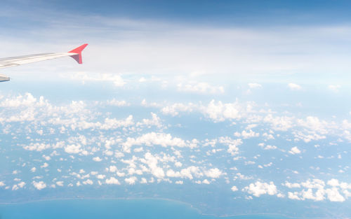 Aerial view of aircraft wing against sky