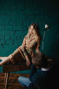 Portrait of young woman sitting on chair at home