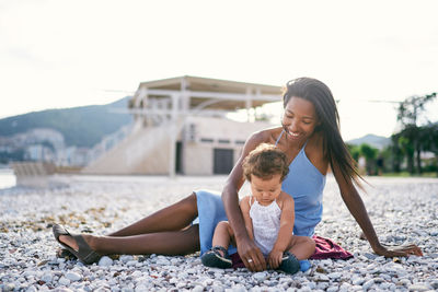 Mother and daughter sitting at beach