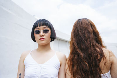 Lesbian couple standing against sky