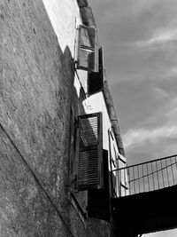 Low angle view of staircase by building against sky