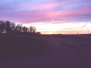 Silhouette of trees on field at sunset