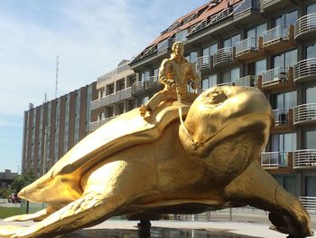 Low angle view of statue against building in city