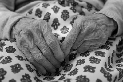 Close-up of woman hand on bed