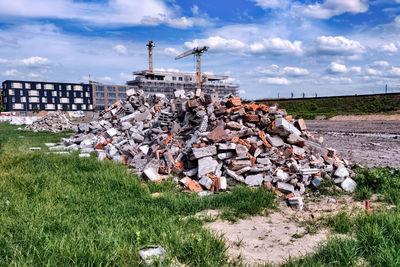 Stack of stones on field against sky