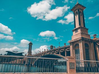 Low angle view of arch bridge in city against sky