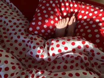 Low section of person covered with resting on bed