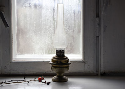 Close-up of electric lamp on window sill