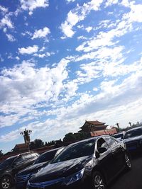 Cars on bridge against cloudy sky