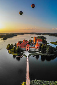 High angle view of castle amidst lake during sunset