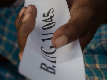 Close-up of human hand with text