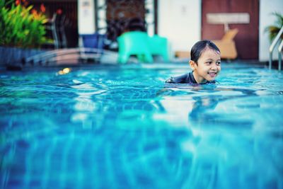 Portrait of smiling boy swimming in pool