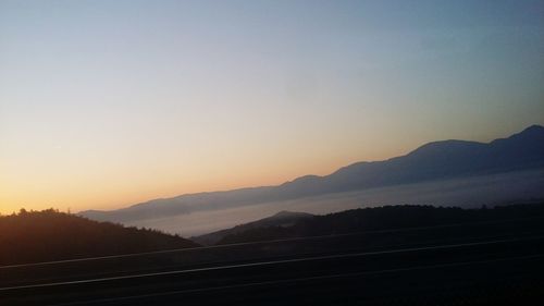 Scenic view of silhouette mountains against sky during sunset