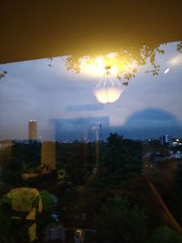 Illuminated cityscape against sky during sunset