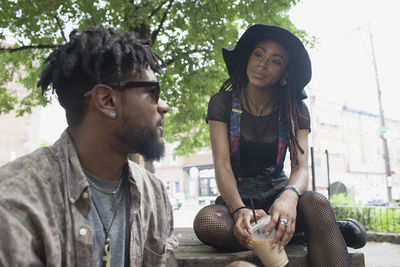 A young man and a young woman at a picnic table with iced coffee.