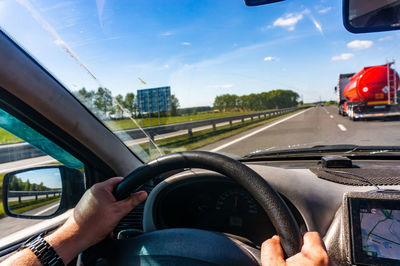 Cropped hand of man driving car