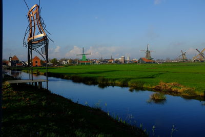 Windmills on grassy field next to canal
