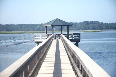 Pier over lake against clear sky