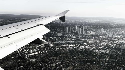 High angle view of airplane flying over cityscape