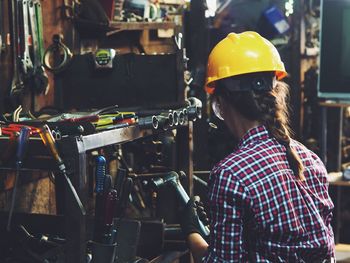 Rear view of female worker working at workshop