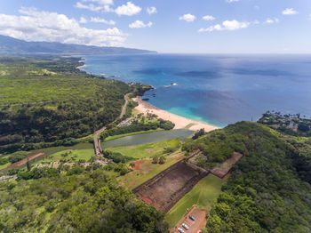 Scenic view of landscape by sea against sky