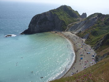 Scenic view of sea and mountains against blue sky