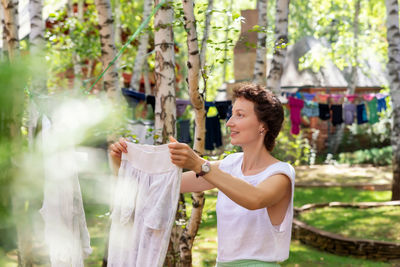 Woman drying clothes in yard