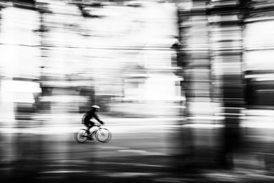 Blurred motion of man riding motorcycle on street