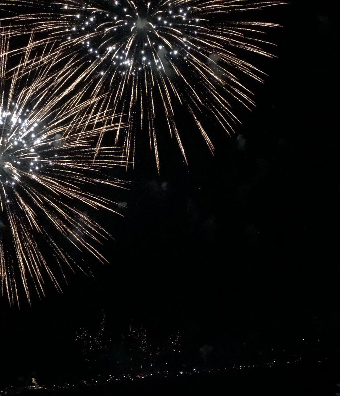 LOW ANGLE VIEW OF FIREWORKS DISPLAY AT NIGHT