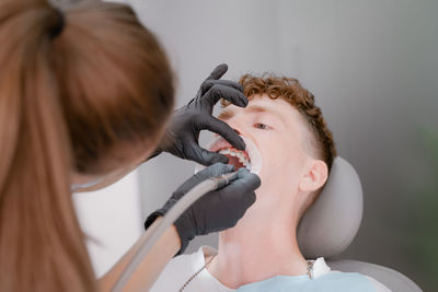 Dentist drills teeth, caries treatment, patient lies on a dental chair, doctor drills teeth